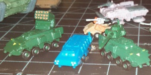Left to right: LRM, APC, and Autocannon variants.  Visible to rear is a JRS "Native Dancer" light strike vehicle and a factory-fresh Type 54 EWAC hover-car